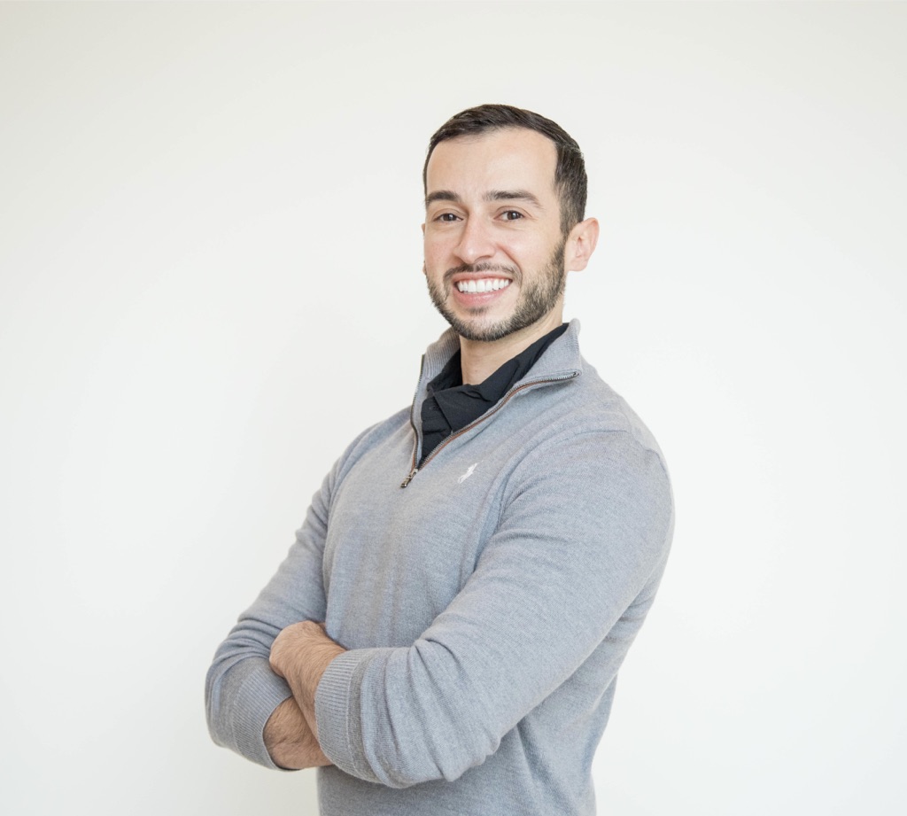 Jesse Armenta smiling in a gray quarter-zip sweater